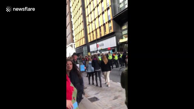 Extinction Rebellion activists climb the entrance of London's YouTube HQ