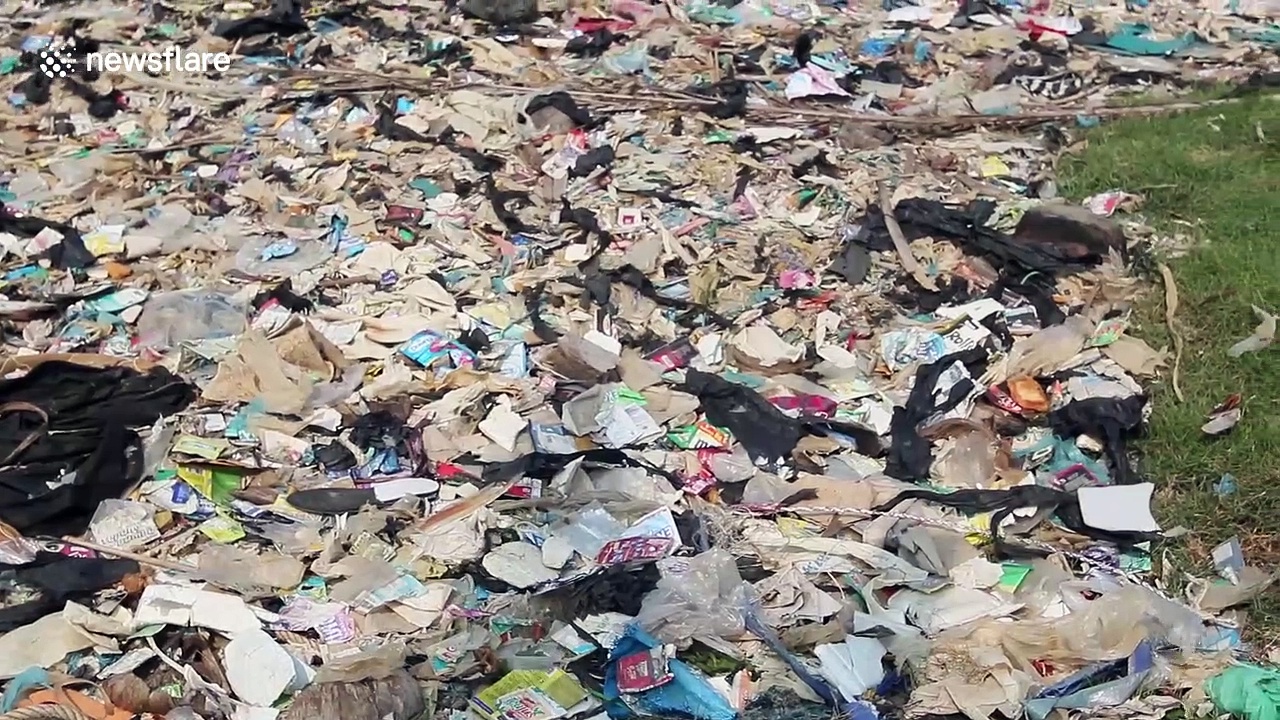 Children play amongst plastic waste piling up on beach in Indonesia
