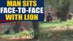 Man jumps inside Lion's Enclosure, sits face to face with lion, video goes viral | OneIndia News