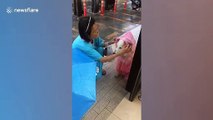 Kind Thai woman gives drenched stray dog a pink rain coat during storm