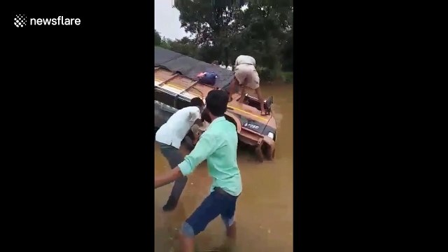 Truck driver flips over on flooded road in west India