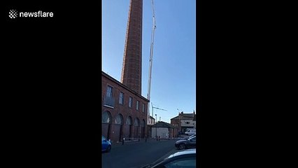 Massive cherry picker arrives to rescue man hanging upside down from 290ft chimney in England