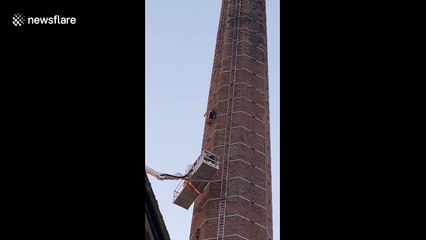 Emergency crews retrieve man stranded on top of chimney in England