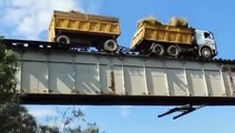 Ce camion est en équilibre sur les rails d'un pont ferroviaire... risqué