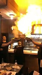Des serveurs flambent des saganákis dans un restaurant grec