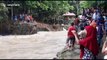Indonesian residents use ropes to cross river after flooding destroys bridge