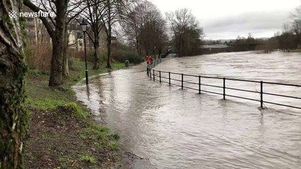 Plucky family cycle through swollen river in Cumbria during Storm Ciara