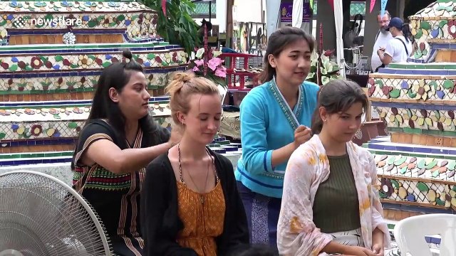 Tourists grit their teeth through sizzling hot fire massages in Thailand