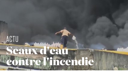 Au Nigéria, un homme tente d'éteindre un violent incendie... à coups de seau d'eau