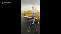 Filipino teenager amazes drivers by riding bike with boxes stacked on his head