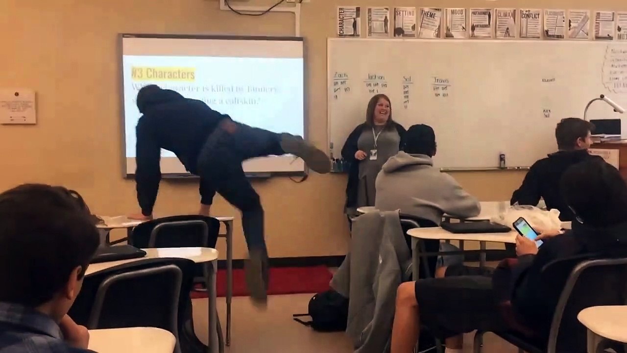 Kid Jumps Over A Desk In Class And Falls