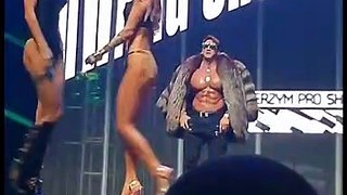 Bodybuilder performance on stage with 2 girls