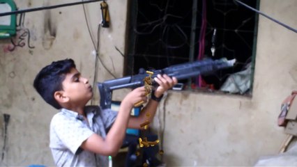 Baccha Gun machine se firing Karke dikha raha hai