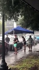 Ces étrangers protègent une voiture décapotable pendant un orage !