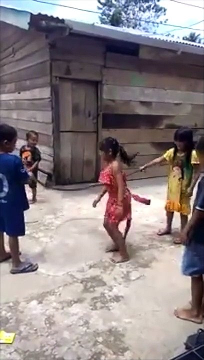 Enfants qui jouent à la corde à sauter avec le corps sans vie d'un serpent