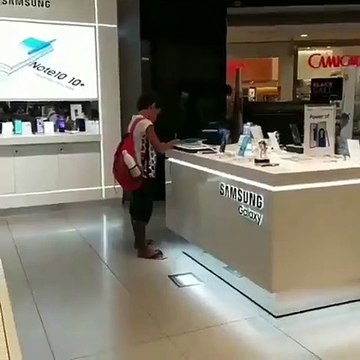 L'employé d'un magasin laisse un enfant utilisé une tablette pour faire ses devoirs