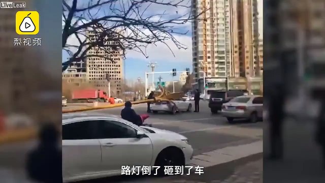 Un lampadaire tombe d'un coup sur une voiture en pleine route !