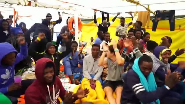 Un grupo de inmigrantes a bordo del Open Arms recibe con alegría la noticia del desembarco a puerto seguro en Italia