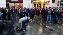 Olympiakos football fans surround busker in London and drown him out with their chants