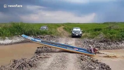 Canal boat takes shortcut over road in Cambodia
