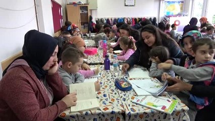 Öğrenci velileri, çocuklarıyla aynı sırayı paylaşıp kitap okuyor