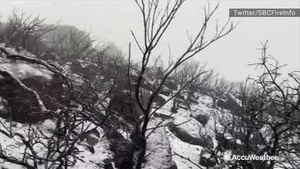 Snow falls where fire raged earlier this week