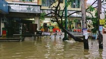 Residents wade through flooded streets after Typhoon Kammuri lashed the Philippines