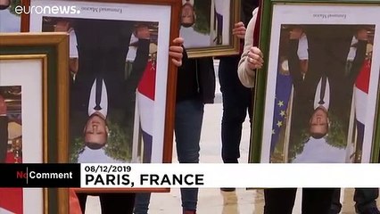 French climate activists hold stolen Macron portraits at protest