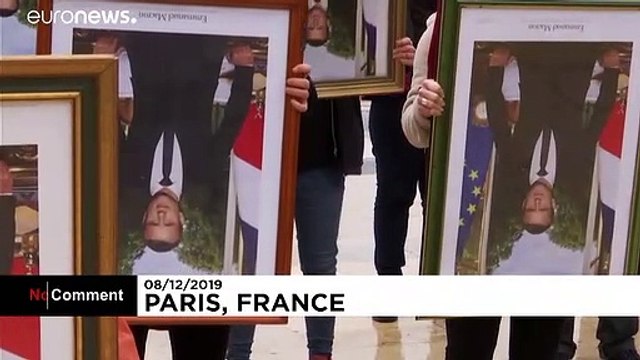 French climate activists hold stolen Macron portraits at protest