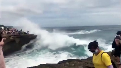 Cette fille veut faire la photo parfaite avec une vague derrière elle