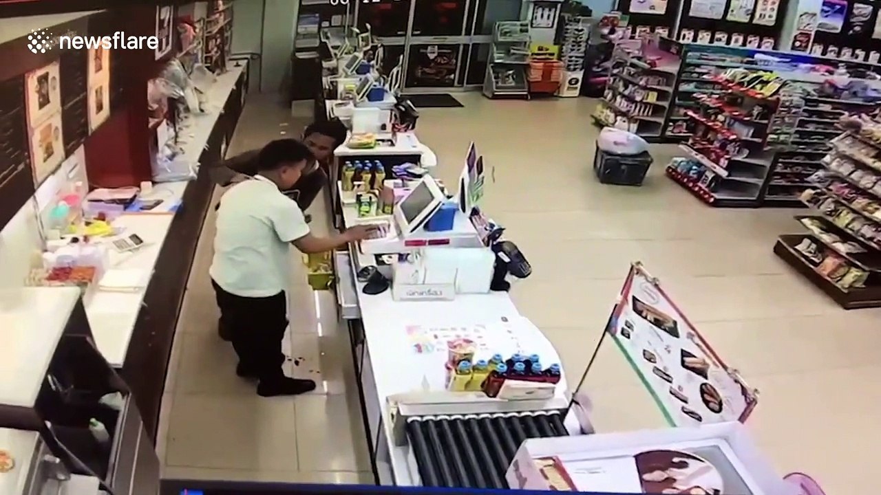 Bizarre moment robber punches shop assistant then stops to check he's OK
