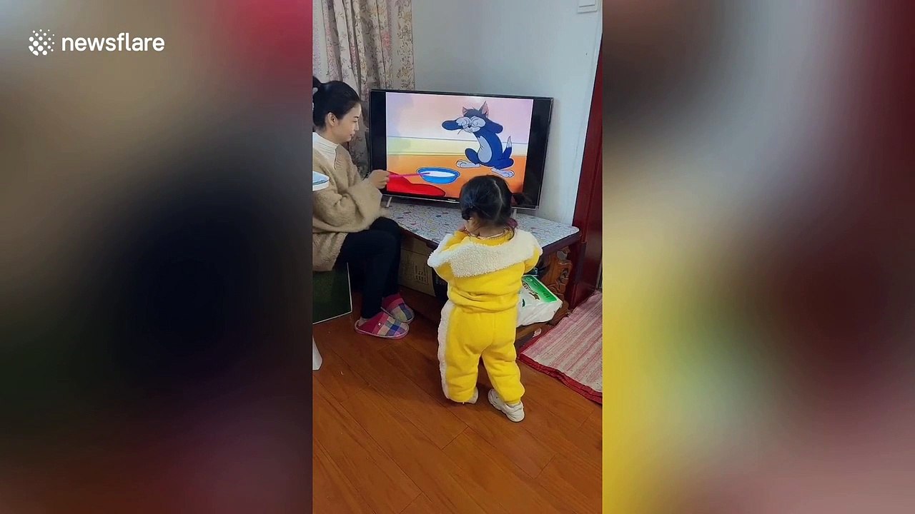 Chinese woman interacts with 'Tom and Jerry' cartoon on TV to entertain her daughter