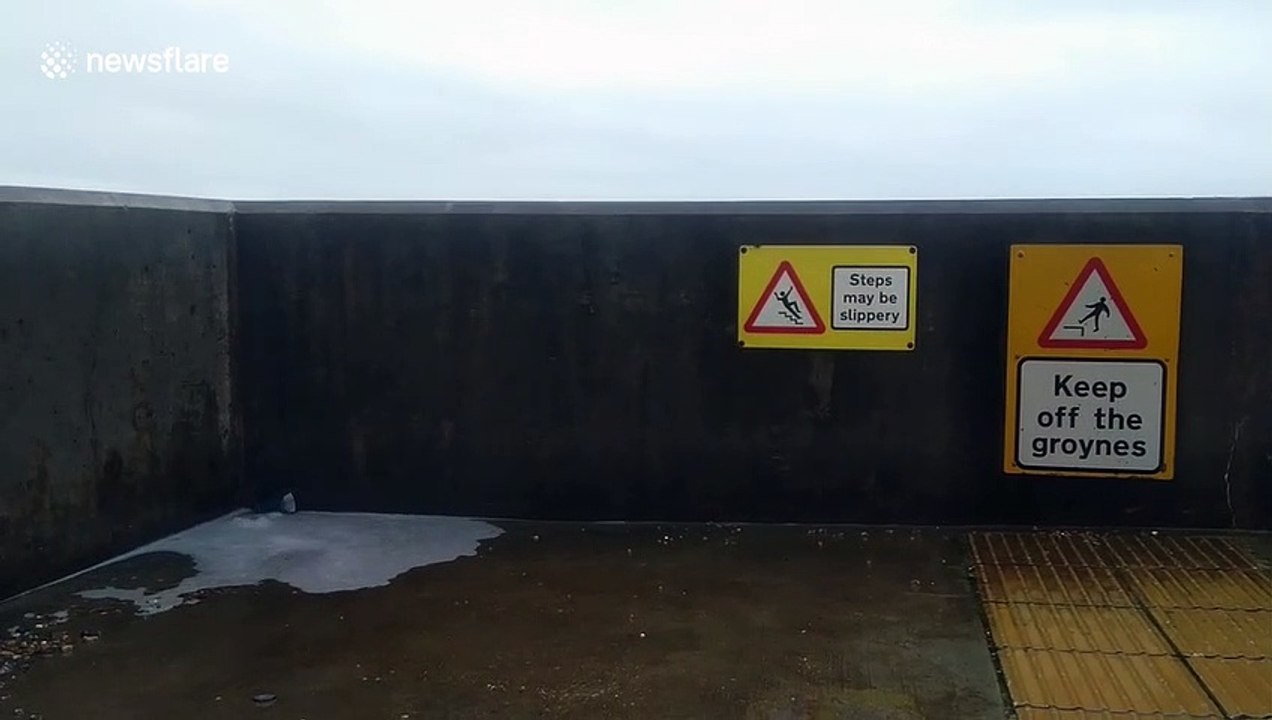 Waves crash over seawall in Brighton, UK