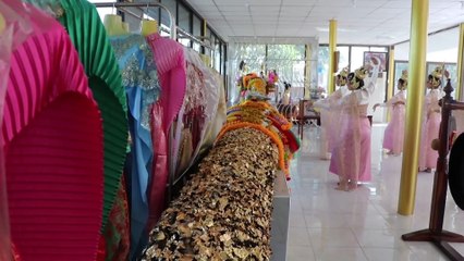Thai dancers make offerings to tree trunk for good fortune