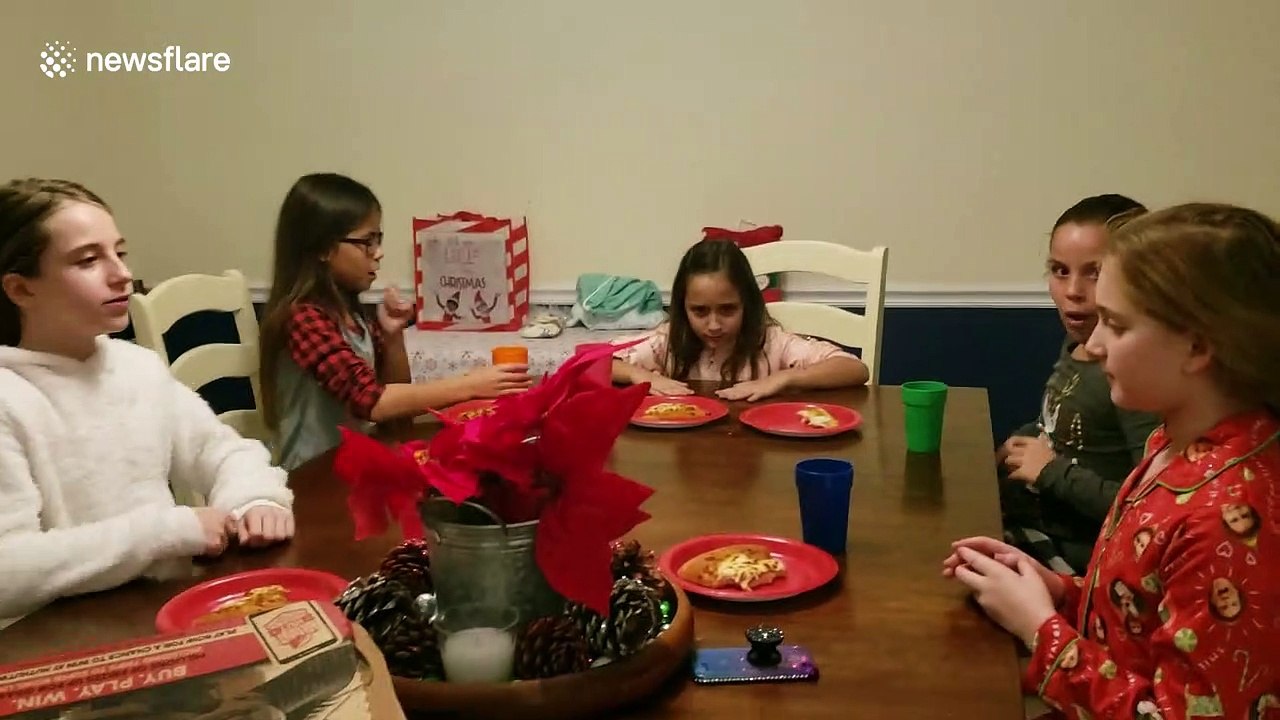 Dog interrupts children's annual Christmas party by stealing pizza right off their plates