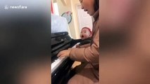 Two-year-old boy sings along with his mum playing the piano