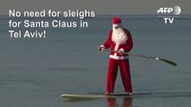 Santa Claus floats to Tel Aviv on his standup paddleboard