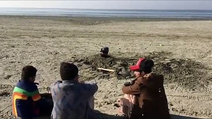 Varios hombres se entierran en una playa de Pakistán durante el eclipse solar para curarse