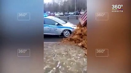 Este camión vuelca su cargamento de arena sobre de un coche de la policía