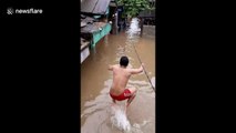 Residents of Jakarta jump into floodwater for a swim as Indonesian capital hit by torrential rains