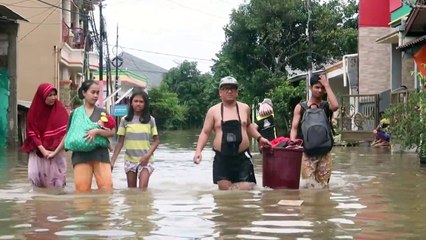 Indonesia: residents wade through flood water