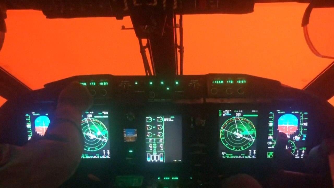 Pilot cockpit view shrouded in orange glow from Australia's bush fires