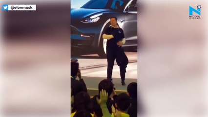 Elon Musk breaks into dance, throws jacket across stage in Shanghai