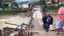 Residents in Indonesia forced to use collapsed bridge after heavy rain wreaks havoc