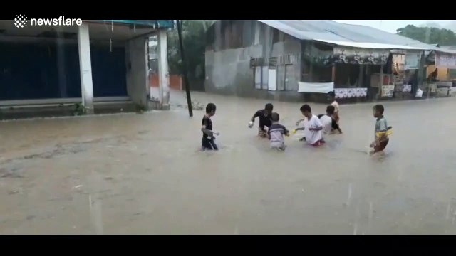 Children play in floodwaters as heavy rains hit Padang, Indonesia