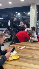 Un hombre cena impasible durante una pelea grupal dentro de un Kebab
