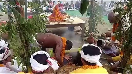 Hindu priest sticks head into firepit for religious festival in northern India