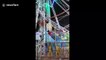 India fairground staff perform nerve-wracking stunt by hanging onto Ferris wheel as it spins around at speed