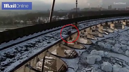 Worker struggles to reach crane before stadium collapses