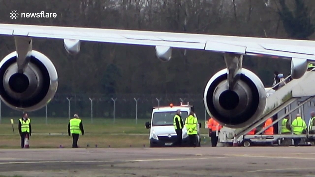 Britons wearing surgical masks leave plane at RAF Brize Norton